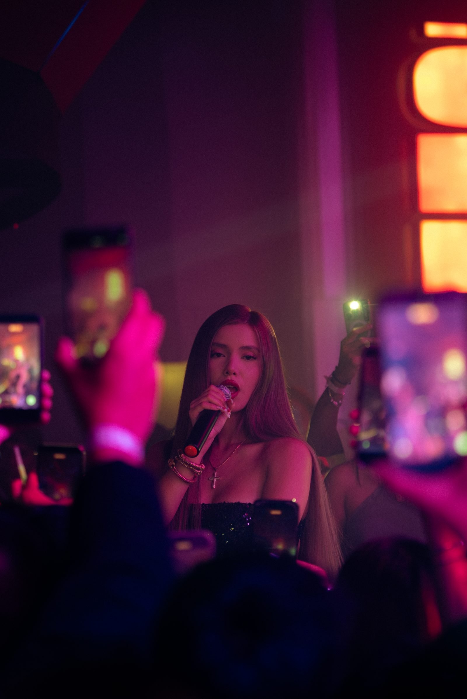 Miranda León cantando rodeada por los celulares del público